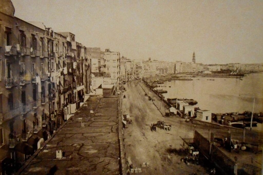 Fotografia ottocentesca di Strada Marina, a Napoli, con passanti e banchi di strada